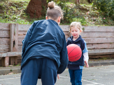 Two students playing basketball